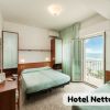 Camera d'hotel con letti verdi e balcone vista mare.