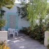 Patio con tavolo e sedie, circondato da piante e fiori.