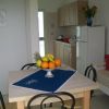 Tavolo con frutta, cucina in legno, ambiente luminoso.