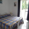 Letto matrimoniale con copriletto a quadri in stanza luminosa.