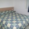 Letto matrimoniale con copriletto a scacchi blu e beige.