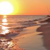 Tramonto su una spiaggia con onde.