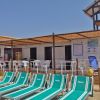 Lettini verdi e un piccolo chiosco sulla spiaggia.