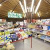 Interno di un negozio con frutta, verdura e scaffali di vari prodotti alimentari.