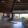 Interno di una sala con finestre e mobili in vimini.
