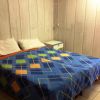 Camera con letto matrimoniale e copriletto colorato, comodino a fianco.