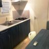 Cucina compatta con lavabo, piano cottura e tavolo.