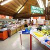 Interno di un supermercato con frutta e verdura in esposizione.