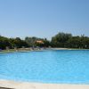 Piscina all'aperto con lettini e ombrelloni arancioni.