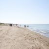 Spiaggia sabbiosa con gente vicino all'acqua.