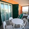 Terrazza con tavolo bianco circondato da sedie pieghevoli bianche.