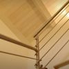 Scala interna con ringhiera in metallo lucido e gradini in legno, vista dal basso.