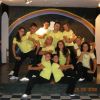 Gruppo di persone su un palco, sfondo con arcobaleno.