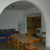 Sala da pranzo con tavolo, sedie e cucina ad arco.