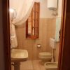 Bagno beige con doccia, lavandino e bidet.