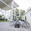 Biciclette bianche in un cortile ghiaioso vicino a una struttura moderna.