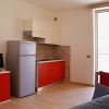 Cucina moderna con mobili rossi e elettrodomestici in un appartamento luminoso.
