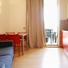 Soggiorno con divano blu, tavolo e sedie rosse, luce soffusa, tende beige.