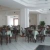 Sala ristorante spaziosa con tavoli apparecchiati e sedie in legno scuro.