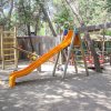 Un parco giochi con uno scivolo arancione.