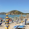 Spiaggia con ombrelloni gialloblù e lettini.