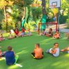 Bambini seduti in cerchio su campo da gioco.