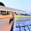 Ristorante moderno con vista sul mare al tramonto.