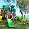 Un parco giochi con scivoli colorati e alberi finti.