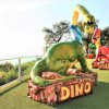 Sculture di dinosauri colorati con scritte 