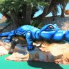Statua di alligatore blu su rocce.