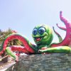 Statua di polpo verde con tentacoli rossi.