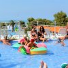 Bambini giocano in piscina con piccole barchette.