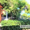 Bungalow arancioni circondati da alberi verdi.