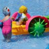 Bambini giocano in piscina con una barchetta.