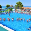 Lezione di acquagym in piscina affollata.