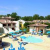 Un complesso con piscina, sedie a sdraio e ombrelloni.