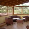 Veranda con mobili in rattan su pavimento in piastrelle.