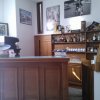 Bancone di un bar con scaffali di liquori e tazze alle spalle.