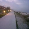 Un sentiero costiero con luci e mare al tramonto.