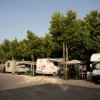Camping con roulotte e tende sotto gli alberi.