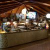 Un bar con tetto in legno e televisore acceso.