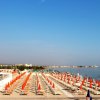 Spiaggia con ombrelloni arancioni e mare calmo.