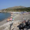Vista di una spiaggia affollata con ombrelloni colorati e mare calmo.