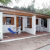 Veranda di una casa bianca con sedie bianche e una sedia a sdraio blu.