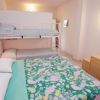 Camera con letto matrimoniale floreale, letto a castello bianco e arredi semplici.