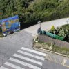 Ingresso di un campeggio con cartellone e strada.