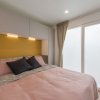 Camera con letto matrimoniale, pareti chiare e tende beige.