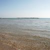 Spiaggia sabbiosa con acqua bassa.