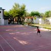 Un campo da gioco all'aperto con persone che giocano con una rete bassa al centro.