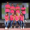 Gruppo sorridente in magliette rosa.